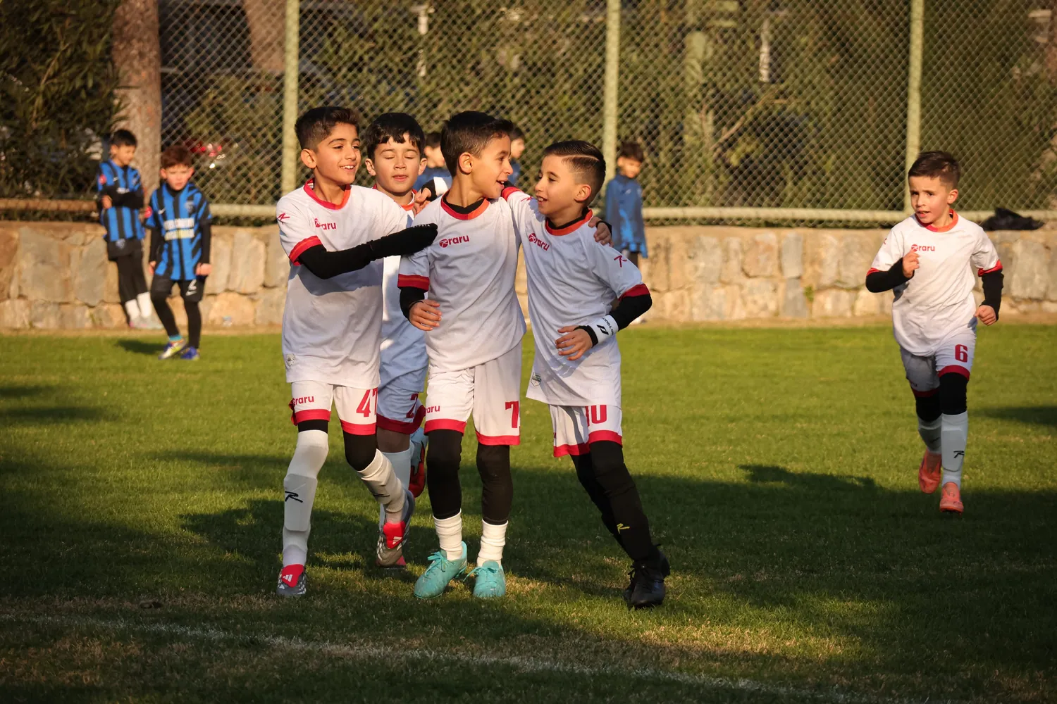 Takım arkadaşlarıyla sevinen genç futbolcular